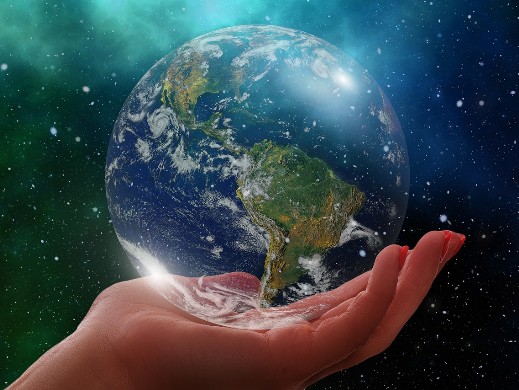 Das Bild zeig eine Hand, die nach oben hin geöffnet ist und eine gläserne Erdkugel hält. Das symbolisiert die Zerbrechlichkeit und Gefährdung des Planeten Erde, der Schöpfung Gottes, die zu bewahren und zu schonen Aufgabe der Christenheit ist.